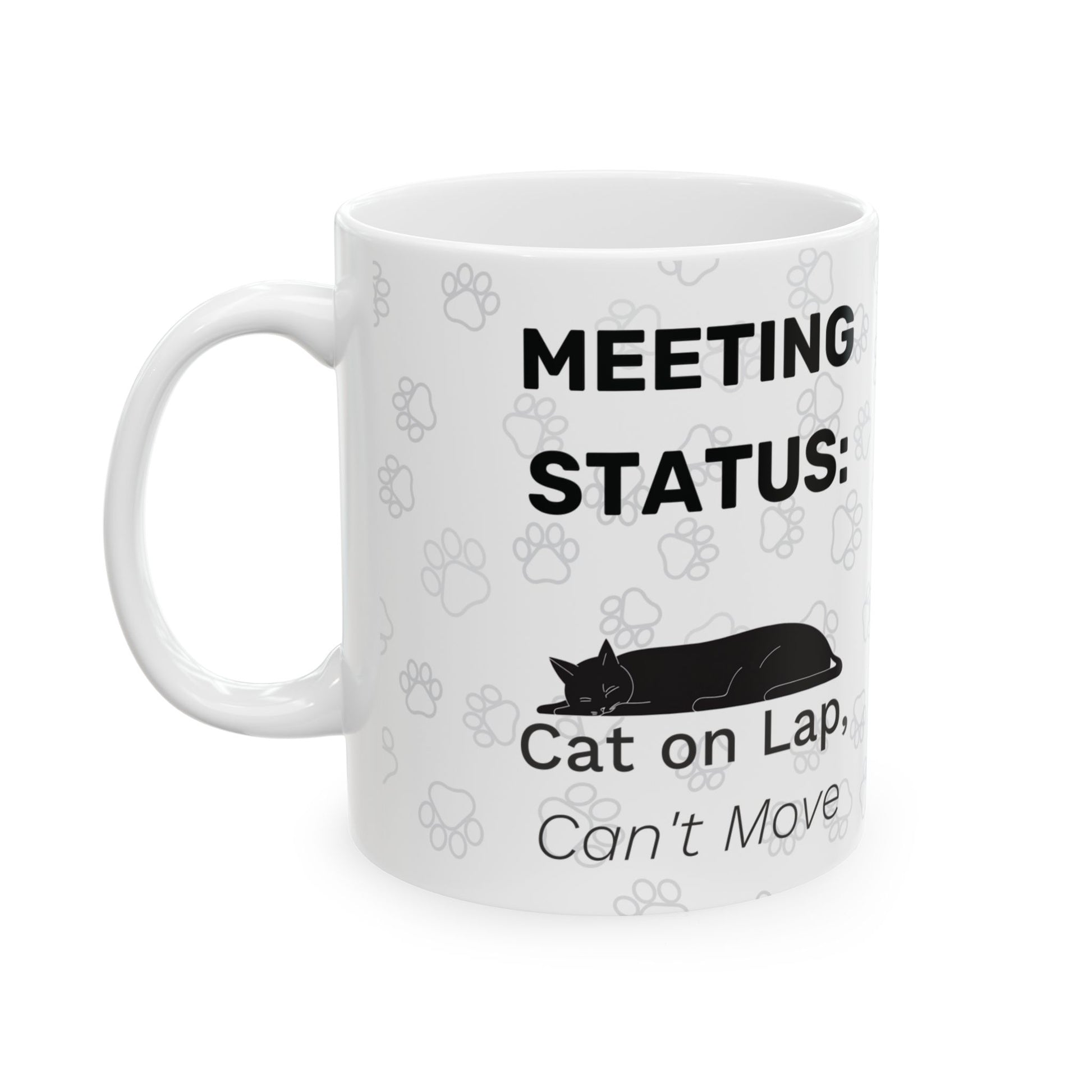 White ceramic mug with "Meeting Status: Cat on Lap, Can't Move" text and black silhouette of sleeping cat design, surrounded by subtle paw print patterns. Cat on Lap Meeting Status Mug for remote workers.