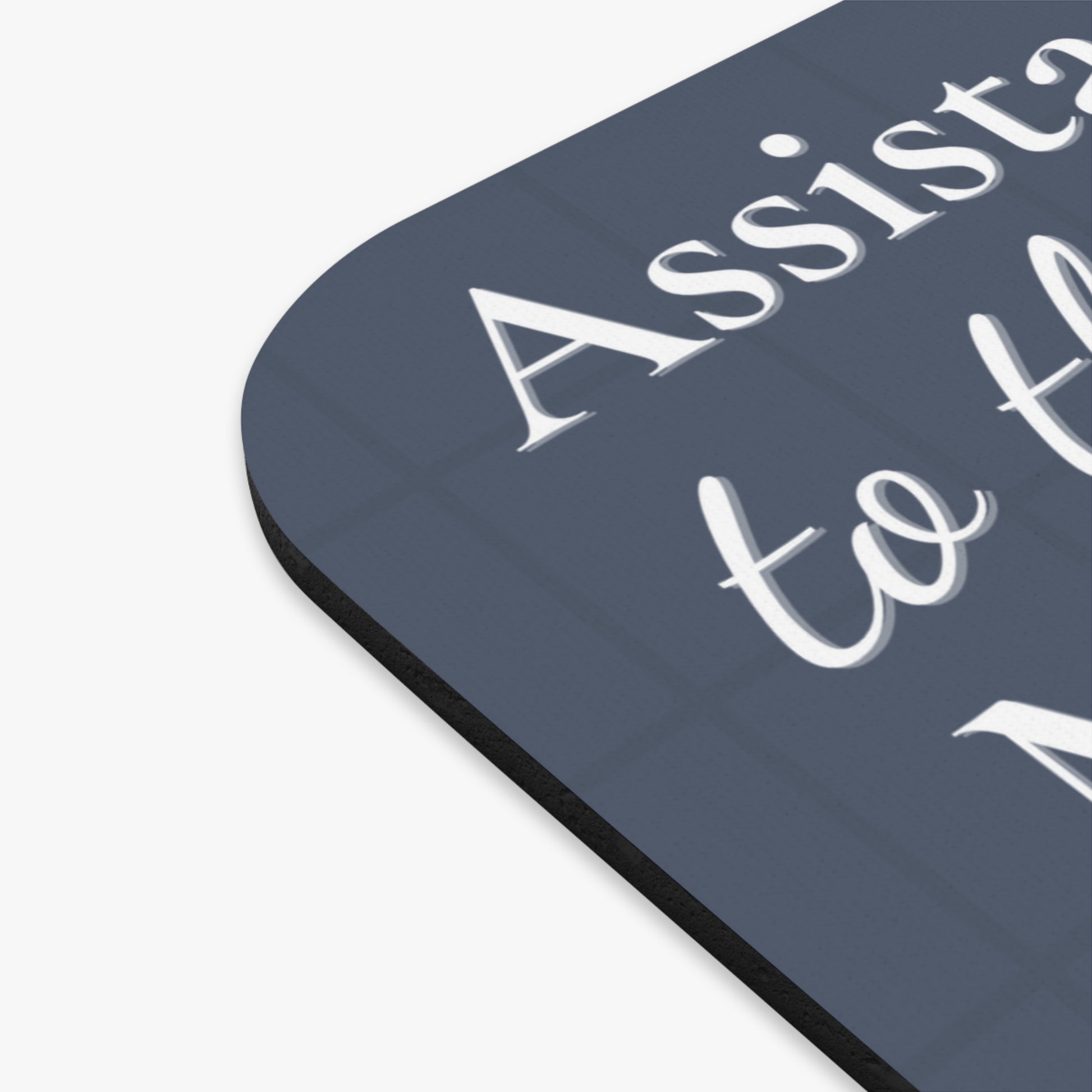 Assistant to the Regional Manager Cat Mousepad featuring white text on slate grey background, showing corner detail of the mousepad with non-slip rubber base and curved edge design